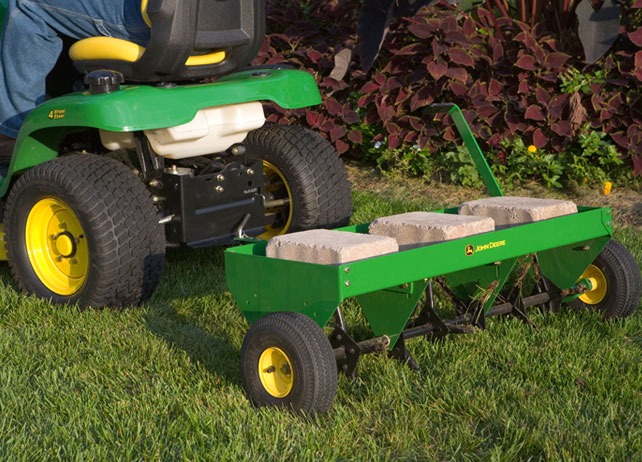 John Deere plug aerator attached to lawn tractor for spring lawn care