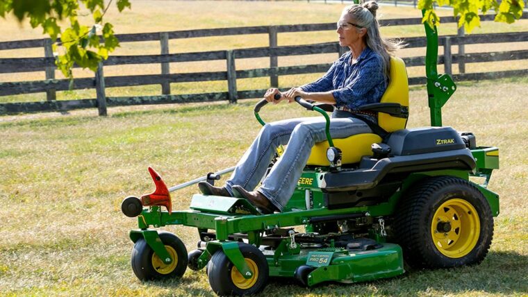 Woman driving on John Deere zero-turn mower