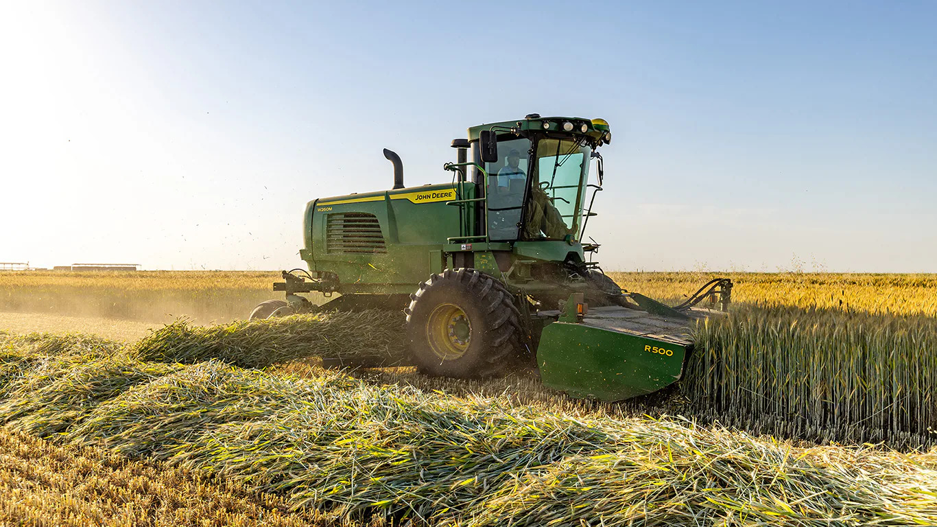 The John Deere W200 windrower helps growers achieve fewer field passes for dense crops, enhancing efficiency and sustainability. 
