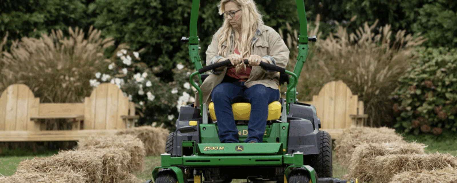 Woman riding a John Deere Z530M in a garden