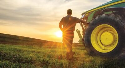 Farmer with John Deere tractor watching the sunset