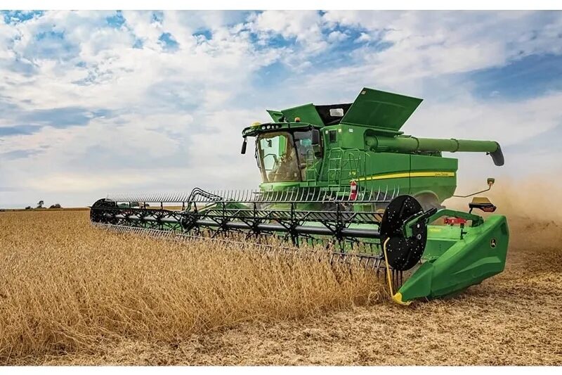 John Deere combine harvesting in a field with a HDF45 hinged-frame flexible cutterbar draper header.
